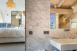 Luxury chalet bathroom with marble walls and a modern sink.