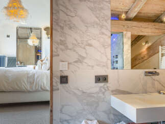 Luxury chalet bathroom with marble walls and a modern sink.