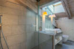 This luxurious bathroom boasts a spacious shower with modern fixtures and sleek gray tile.