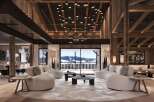 This luxurious chalet boasts a stunning open-plan living area with floor-to-ceiling windows offering breathtaking mountain views.