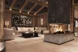 This luxurious chalet boasts a stunning centerpiece: a large, modern fireplace with a rustic stone surround, creating a warm and inviting atmosphere.