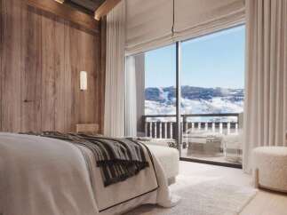 Wake up to breathtaking mountain views from this luxurious bedroom.