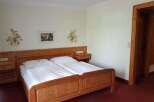 This cozy bedroom features a comfortable wooden bed with fresh white linens, perfect for a relaxing stay.