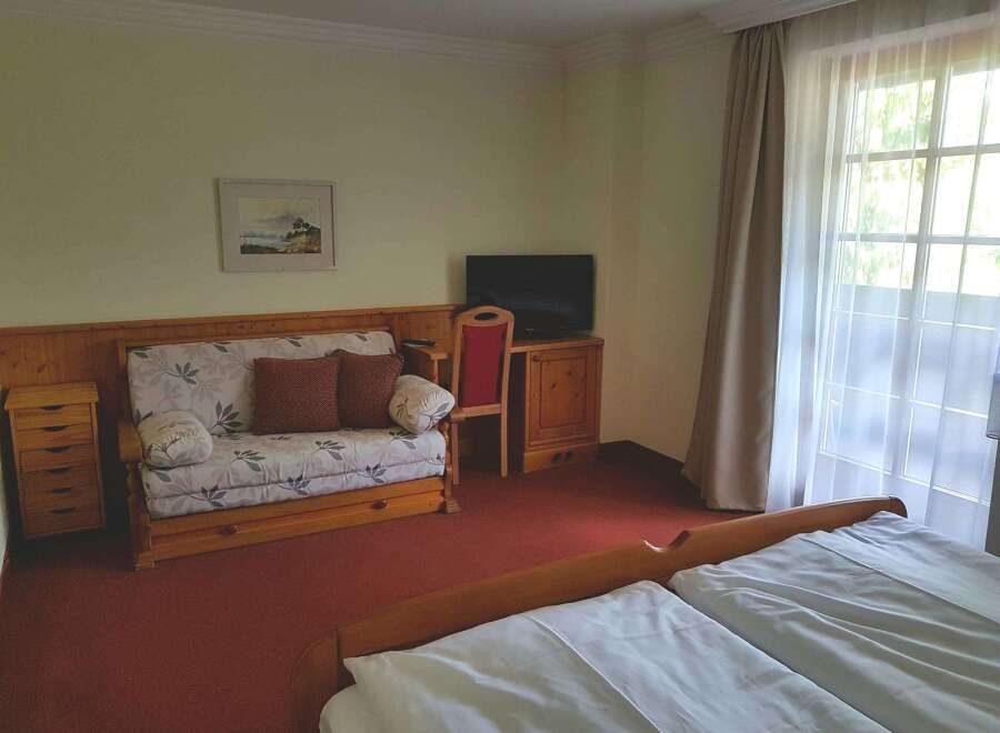 Cozy hotel room featuring a comfortable sofa and a well-appointed desk area.