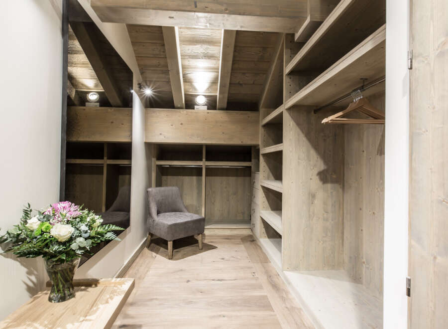 Step into luxury with this stunning walk-in closet, featuring custom wooden shelving and ample storage space.