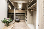 Step into luxury with this stunning walk-in closet, featuring custom wooden shelving and ample storage space.