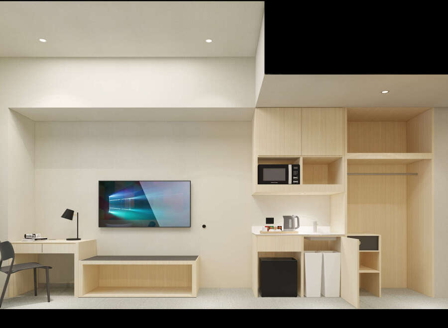 This modern hotel room boasts a minimalist design with built-in wooden cabinetry, including a workspace with a chair and a TV, and a kitchenette area with a microwave and kettle.