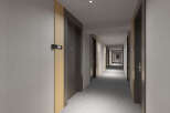 This hotel boasts a modern and minimalist hallway design, featuring sleek dark doors accented with light wood trim.