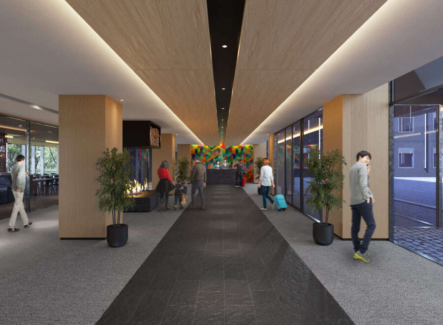 This hotel boasts a modern and spacious lobby with a sleek design, featuring a long hallway with a dark grey tiled floor and wood paneled ceiling.