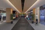 This hotel boasts a modern and spacious lobby with a sleek design, featuring a long hallway with a dark grey tiled floor and wood paneled ceiling.