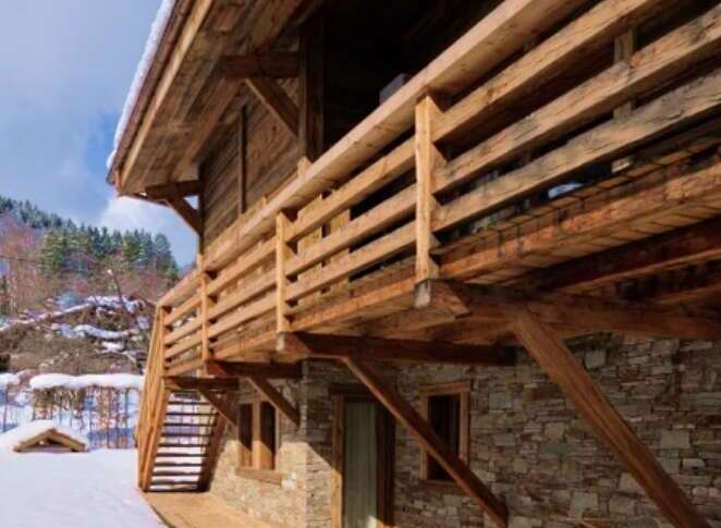 This stunning chalet boasts a rustic-chic design, featuring exposed wooden beams and a stone exterior.