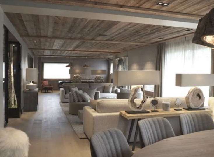 This stunning chalet boasts a rustic-chic interior with a wood-paneled ceiling and expansive living area.
