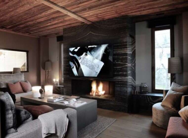 Luxurious chalet featuring a stunning marble fireplace, large screen TV, and comfortable seating area.