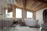 Luxurious bathroom with a freestanding bathtub and wooden ceiling.