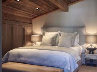 Luxurious chalet bedroom with wooden beamed ceiling and plush bedding.