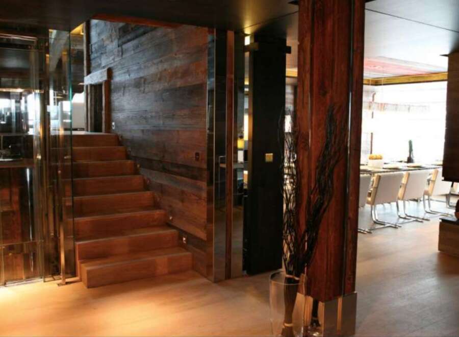 This stunning property boasts a unique blend of rustic and modern design, highlighted by a striking wooden staircase and glass elevator.