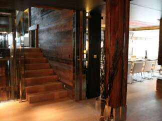 This stunning property boasts a unique blend of rustic and modern design, highlighted by a striking wooden staircase and glass elevator.