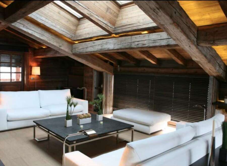 Luxury chalet with exposed wooden beams and skylights.