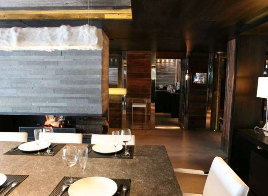 This luxurious chalet boasts a stunning stone fireplace, creating a cozy and inviting atmosphere.