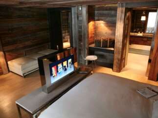Luxury chalet bedroom with rustic wood walls and modern amenities.