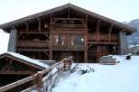 This stunning chalet boasts a rustic-chic design with exposed wooden beams and stone accents.