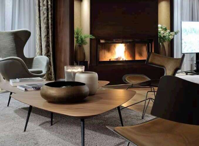 Luxurious living room featuring a stunning fireplace as the focal point, complemented by plush seating and modern coffee tables.