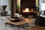 Luxurious living room featuring a stunning fireplace as the focal point, complemented by plush seating and modern coffee tables.