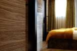 Luxurious bedroom with wood paneling and hardwood floors.