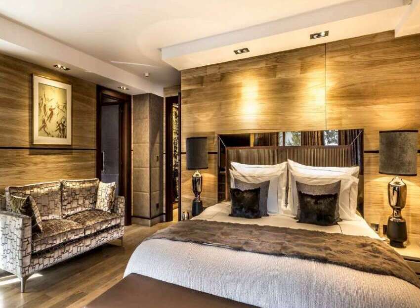 Luxurious chalet bedroom with wood paneling, plush furnishings, and a cozy atmosphere.