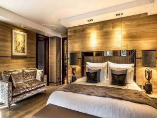 Luxurious chalet bedroom with wood paneling, plush furnishings, and a cozy atmosphere.