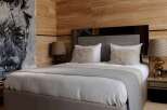 Luxurious bedroom with wood paneling and a plush bed.
