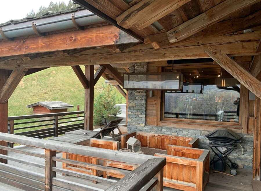 This stunning chalet boasts a spacious outdoor deck with breathtaking mountain views, perfect for enjoying the fresh air and stunning scenery.