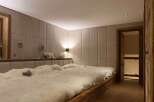Luxurious chalet bedroom with plush sheepskin bedding and bespoke wall paneling.