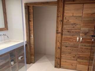 Luxury bathroom boasts a stunning reclaimed wood sliding door and double doors, adding rustic charm.
