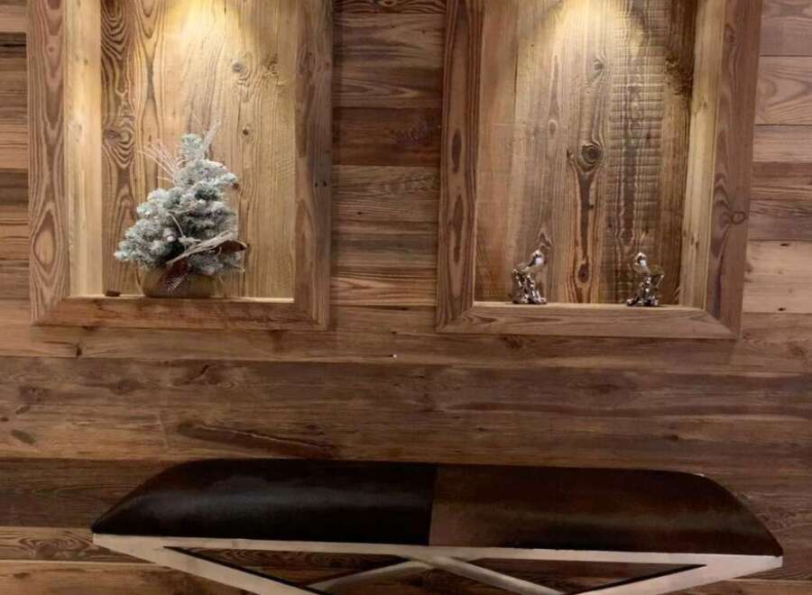Rustic elegance meets modern design in this stunning space, featuring reclaimed wood paneling and a sleek, metal-legged bench.
