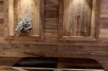 Rustic elegance meets modern design in this stunning space, featuring reclaimed wood paneling and a sleek, metal-legged bench.