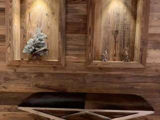Rustic elegance meets modern design in this stunning space, featuring reclaimed wood paneling and a sleek, metal-legged bench.