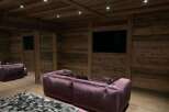 This luxurious home theater boasts stunning reclaimed wood walls and a coffered ceiling, creating a warm and inviting ambiance.