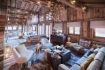 This stunning chalet boasts a spacious open-plan living area with exposed wooden beams and a cozy fireplace, perfect for relaxing after a day on the slopes.