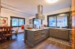 Stunning kitchen with modern gray cabinets and a sleek island, featuring a wine rack and ample counter space.
