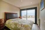 Wake up to breathtaking lake views from this luxurious bedroom.