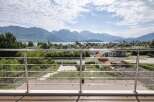 Luxury mountain view home with a spacious balcony featuring modern stainless steel railings and composite decking.