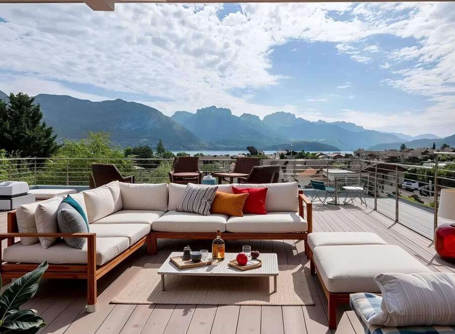 Luxury mountain view deck with sectional sofa and outdoor coffee table.