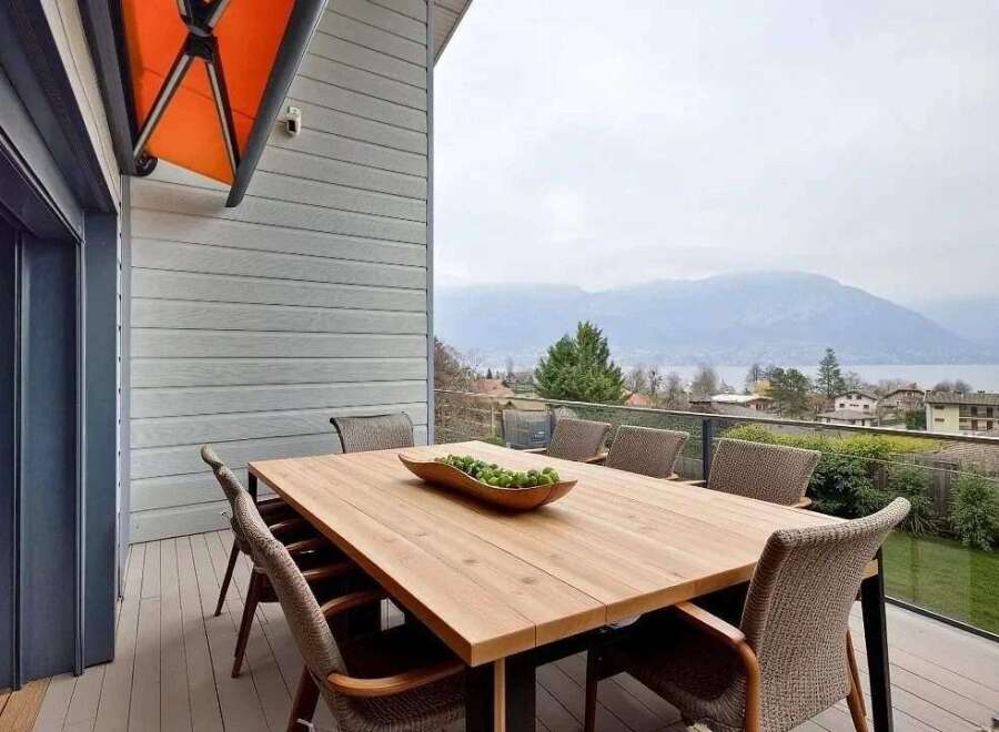 Luxury mountain view home with spacious deck and outdoor dining area.