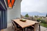 Luxury mountain view home with spacious deck and outdoor dining area.