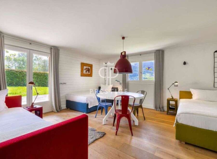 Discover a charming bedroom with a vibrant red bed frame, complemented by a cozy seating area.