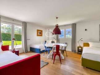 Discover a charming bedroom with a vibrant red bed frame, complemented by a cozy seating area.