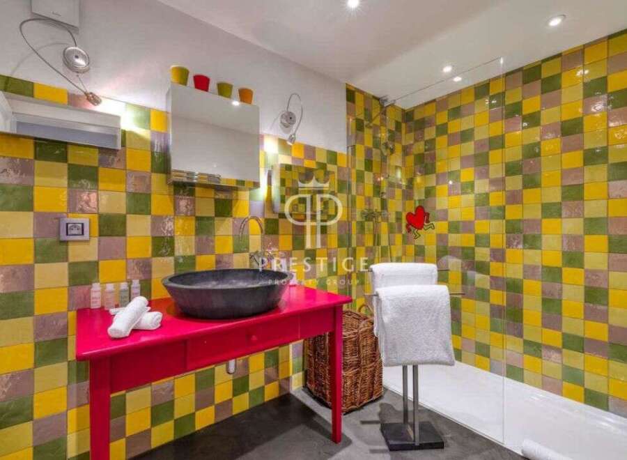 This vibrant bathroom features a unique tile design, creating a cheerful and inviting atmosphere.