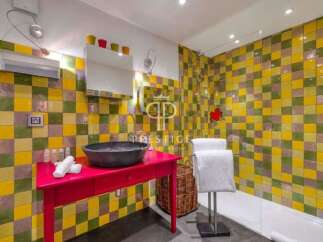 This vibrant bathroom features a unique tile design, creating a cheerful and inviting atmosphere.