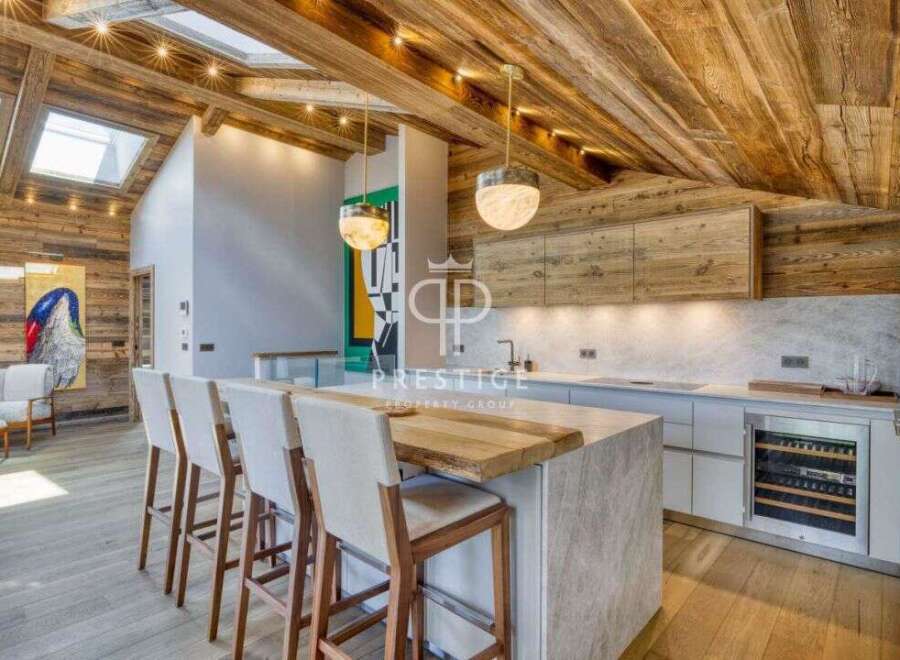 Experience luxury living in this stunning property, featuring a modern kitchen with a stylish island and seating.